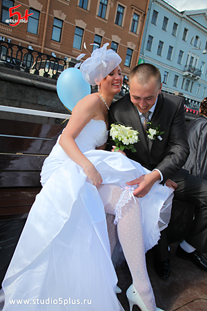 Жених снимает подвязку с ноги невесты