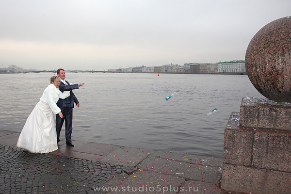 Молодожены бьют свадебные бокалы на стрелке В. О. в Санкт-Петербурге